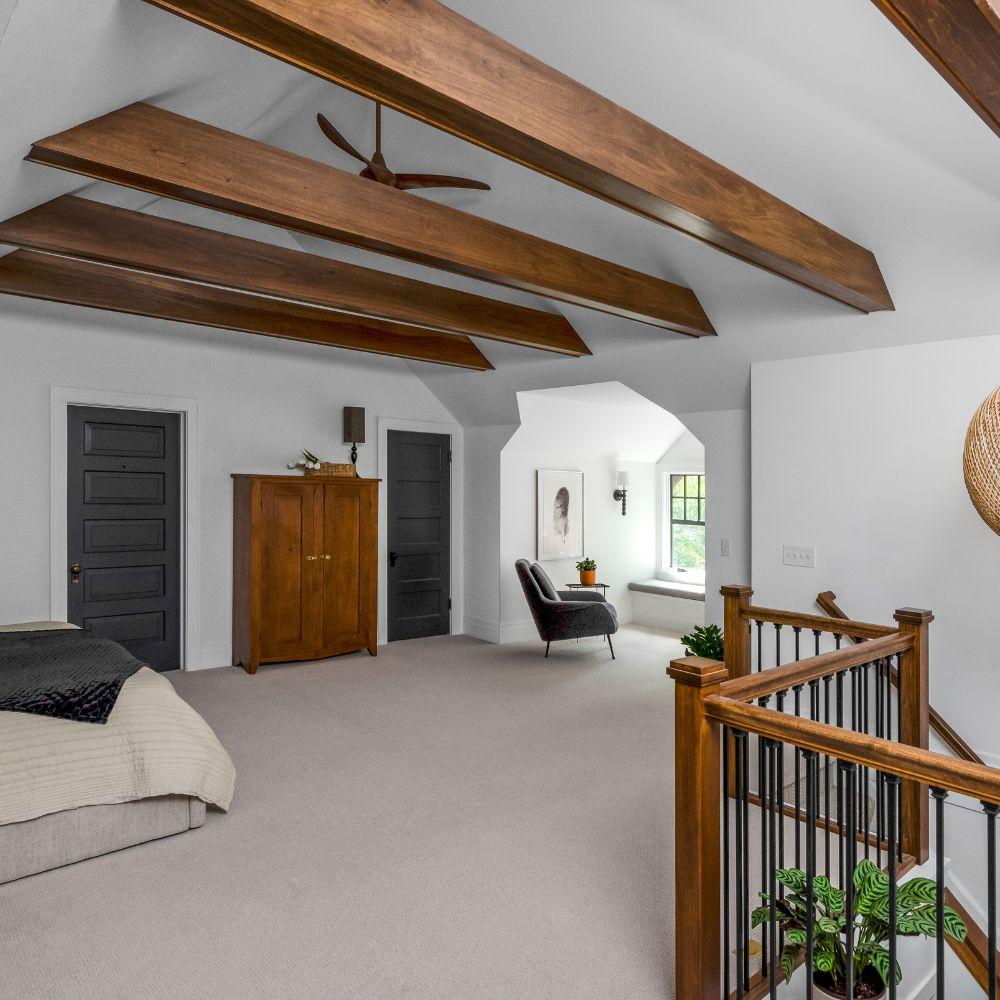 white bedroom in attic with wood beams